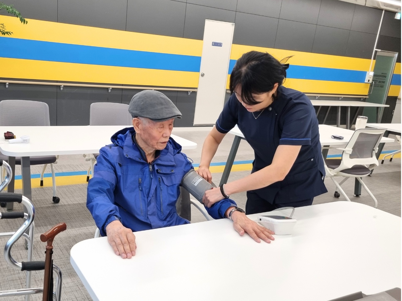 간호사가 어르신의 혈압을 확인하는 모습